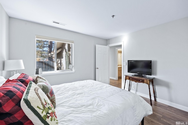 bedroom with dark hardwood / wood-style flooring