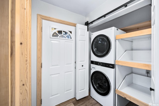 clothes washing area featuring stacked washing maching and dryer and dark hardwood / wood-style flooring