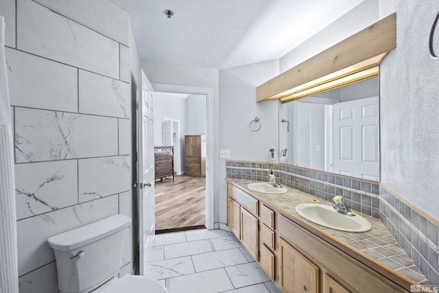 bathroom with hardwood / wood-style floors, vanity, toilet, and tile walls