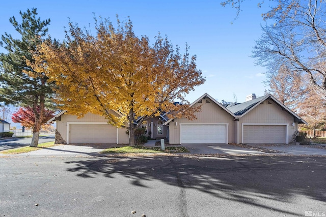 view of property hidden behind natural elements featuring a garage