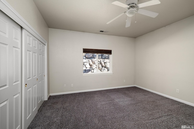 unfurnished bedroom featuring ceiling fan, dark colored carpet, and a closet