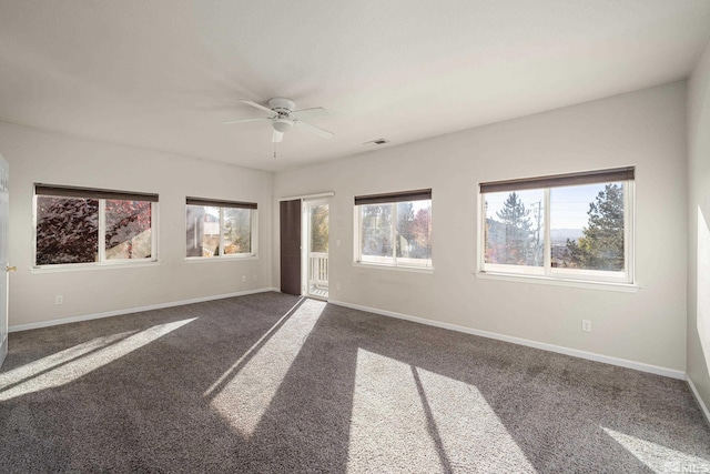 carpeted empty room featuring a wealth of natural light and ceiling fan