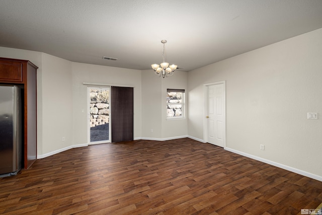 empty room with a chandelier and dark hardwood / wood-style flooring