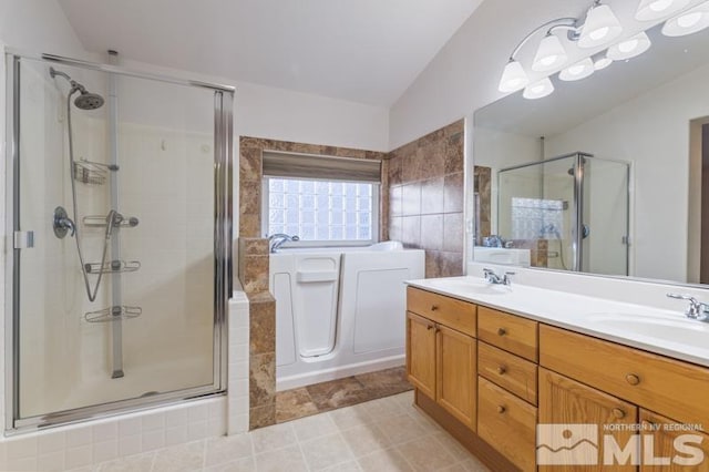 bathroom featuring vanity, tile patterned floors, vaulted ceiling, and a shower with shower door