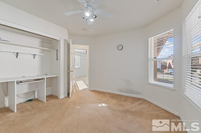 unfurnished bedroom with a closet, light colored carpet, and ceiling fan