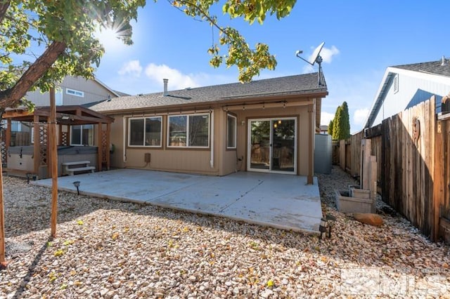 back of property featuring a hot tub and a patio area