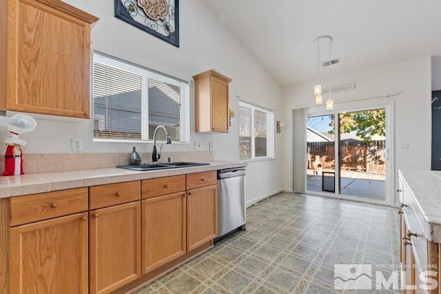 kitchen featuring tile countertops, hanging light fixtures, sink, and vaulted ceiling