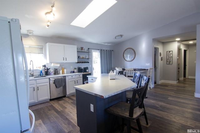 kitchen featuring dishwasher, plenty of natural light, white cabinetry, and white refrigerator