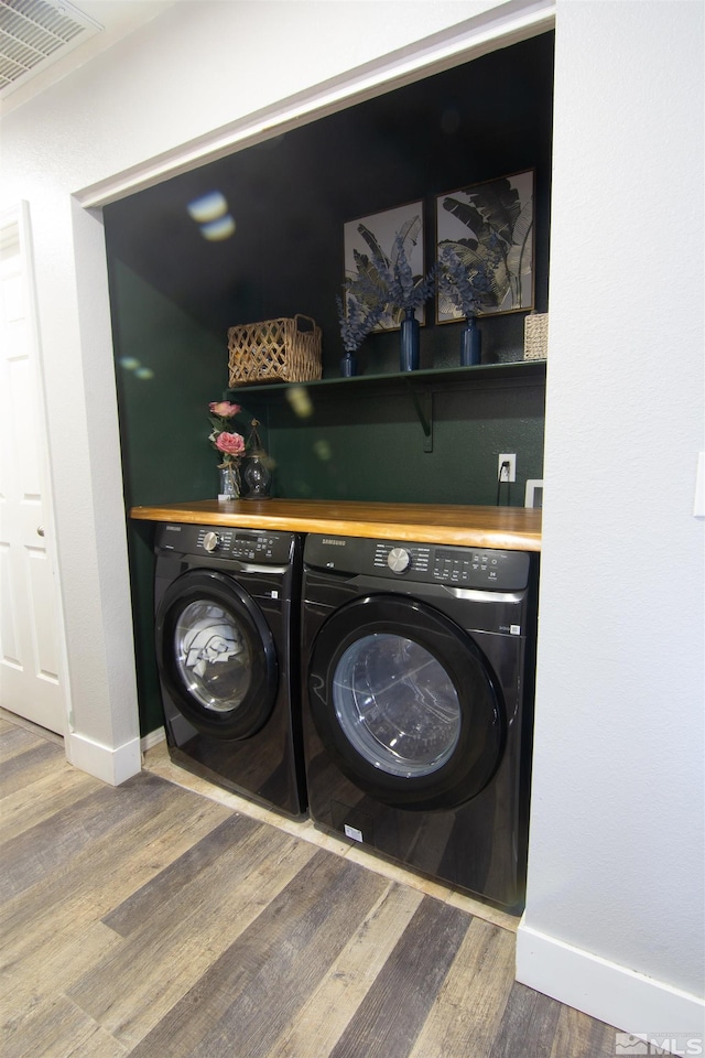 laundry area with hardwood / wood-style floors and independent washer and dryer