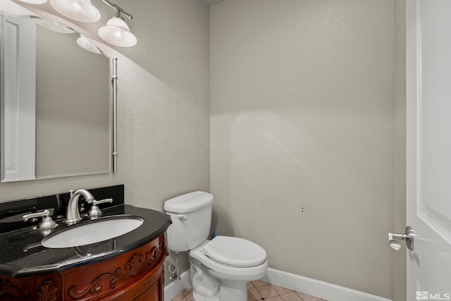 bathroom with toilet, vanity, and tile patterned flooring