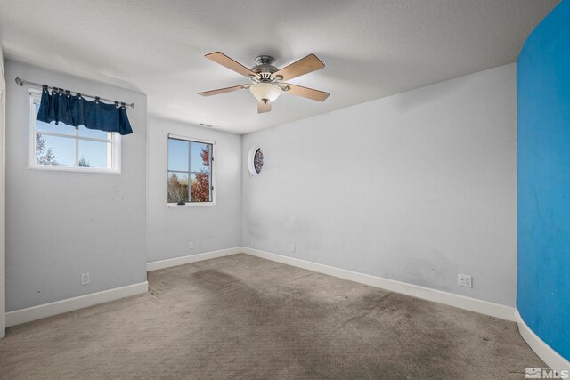 carpeted empty room with a textured ceiling and ceiling fan