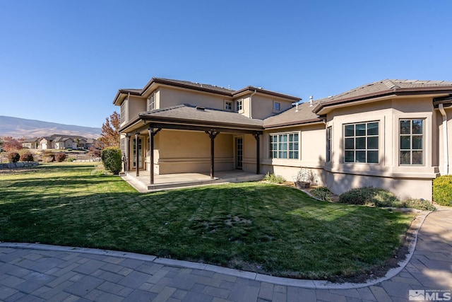 exterior space featuring a front lawn and a patio