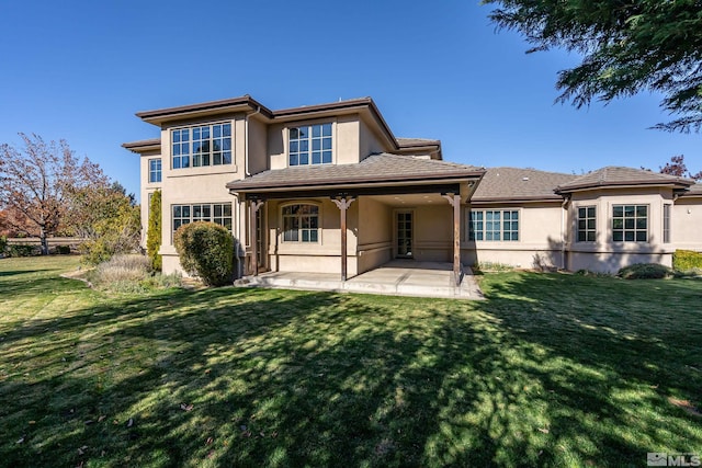 back of house featuring a lawn and a patio area