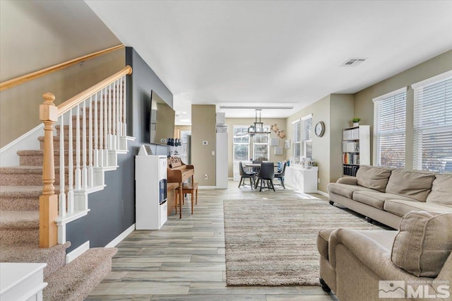 living room with light hardwood / wood-style flooring and an inviting chandelier