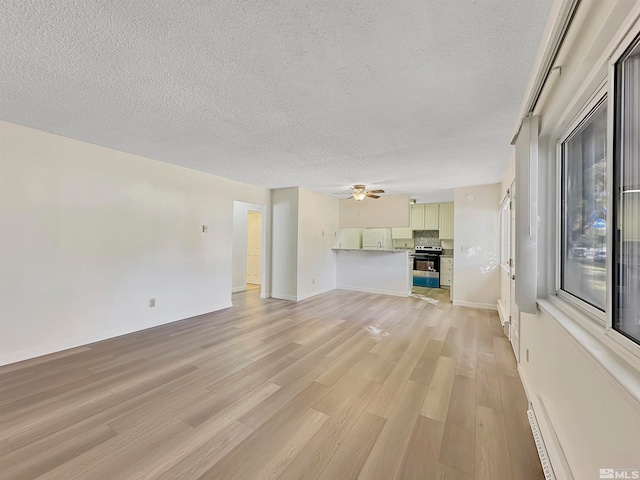 unfurnished living room featuring ceiling fan, a textured ceiling, and light hardwood / wood-style floors