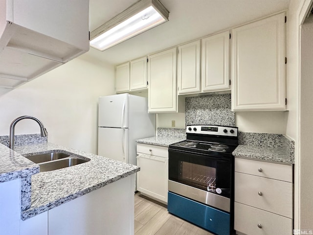 kitchen featuring light hardwood / wood-style floors, sink, light stone countertops, white fridge, and electric stove