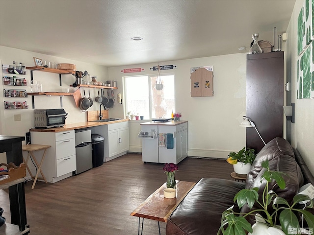 kitchen featuring stainless steel fridge, white cabinetry, sink, and dark hardwood / wood-style flooring