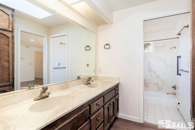 bathroom featuring hardwood / wood-style floors, vanity, tub / shower combination, and a skylight