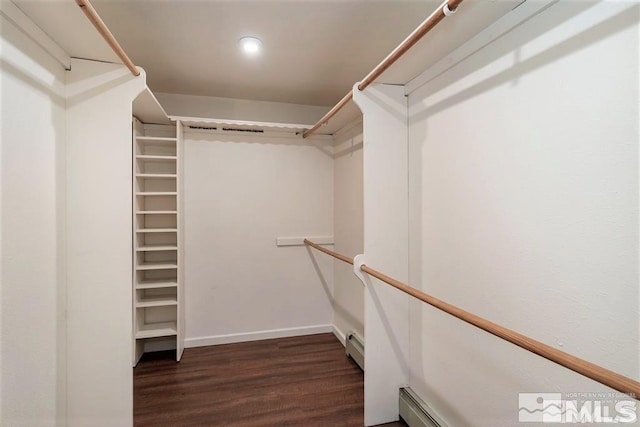 walk in closet featuring baseboard heating and dark hardwood / wood-style flooring