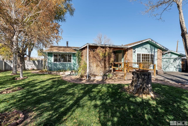 back of house featuring a lawn and a garage