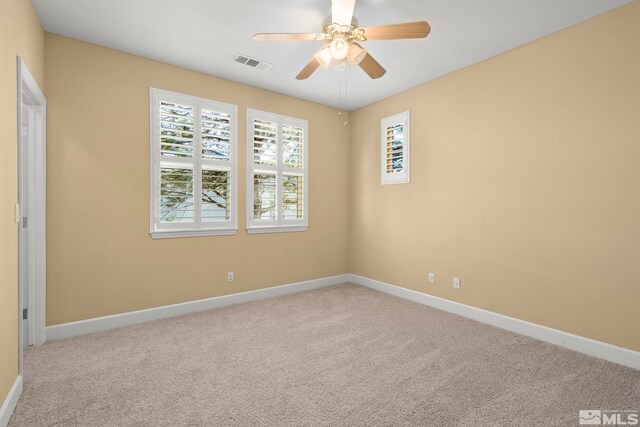 carpeted spare room with ceiling fan