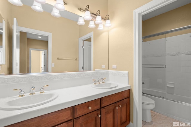 full bathroom with tile patterned flooring, vanity, toilet, and bath / shower combo with glass door