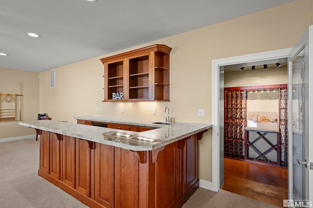 kitchen featuring sink, a textured ceiling, light carpet, and kitchen peninsula