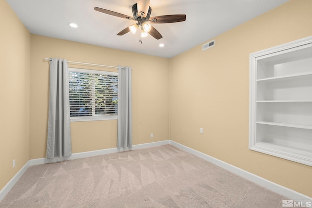 carpeted spare room with ceiling fan