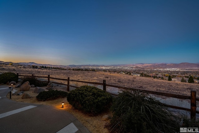 yard at dusk featuring a mountain view