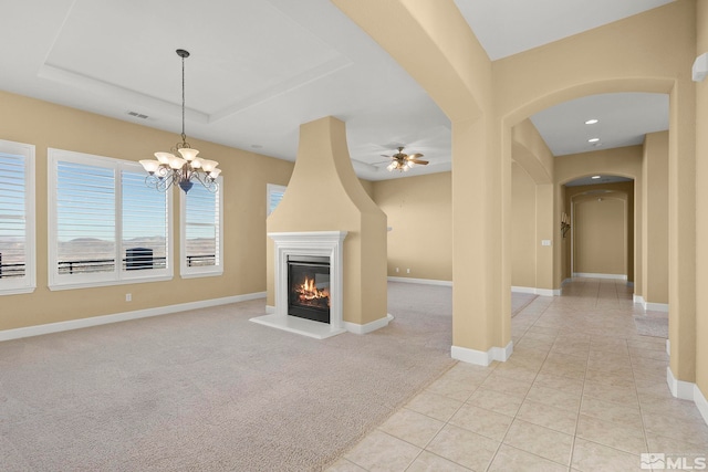 unfurnished living room with ceiling fan with notable chandelier and light carpet