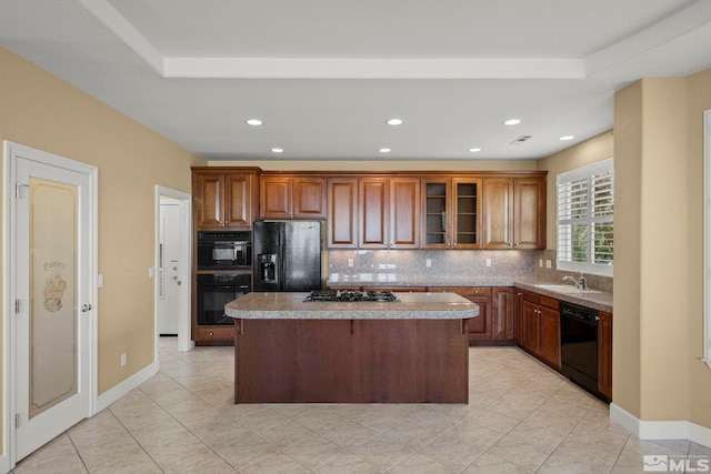 kitchen with black appliances, light tile patterned flooring, decorative backsplash, sink, and a center island