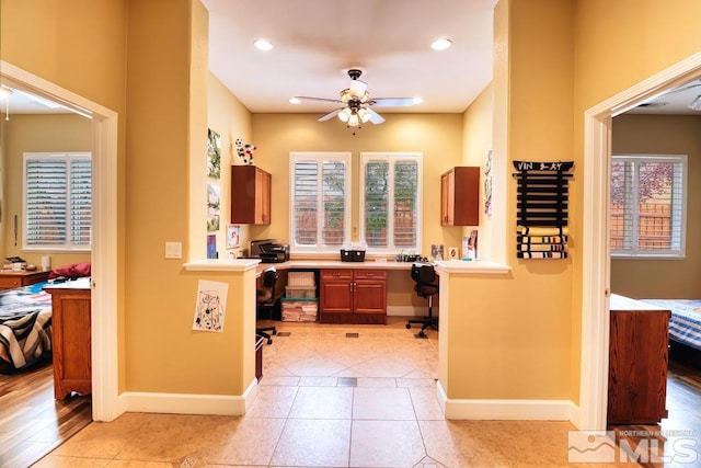 kitchen with built in desk, ceiling fan, and light wood-type flooring