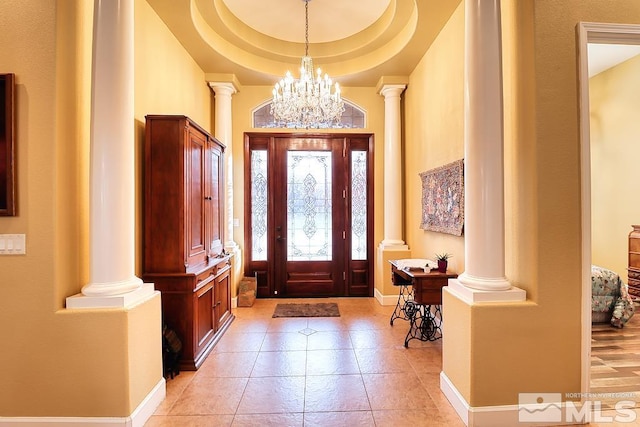 foyer entrance featuring a chandelier and a raised ceiling