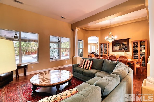 living room featuring wood-type flooring, ornate columns, and ceiling fan with notable chandelier