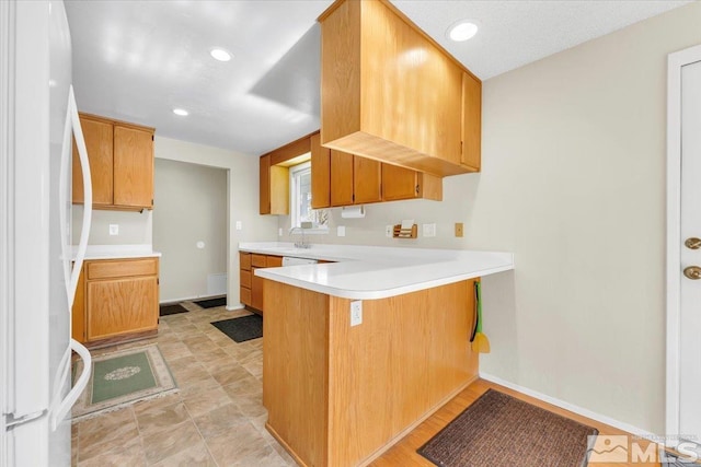 kitchen featuring kitchen peninsula, sink, and white refrigerator