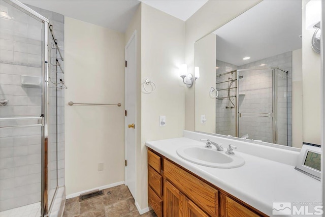 bathroom with vanity and a shower with shower door