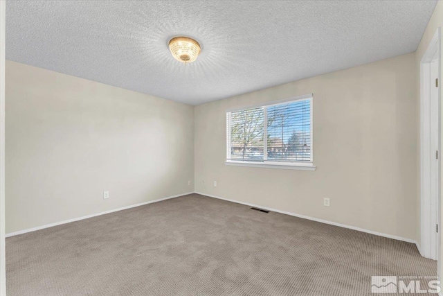 carpeted empty room with a textured ceiling