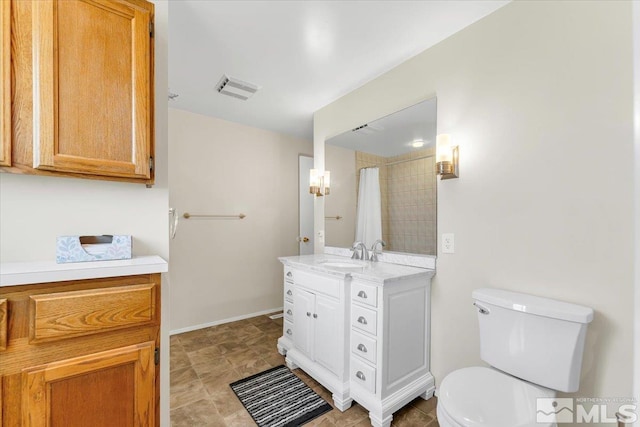 bathroom featuring curtained shower, vanity, and toilet