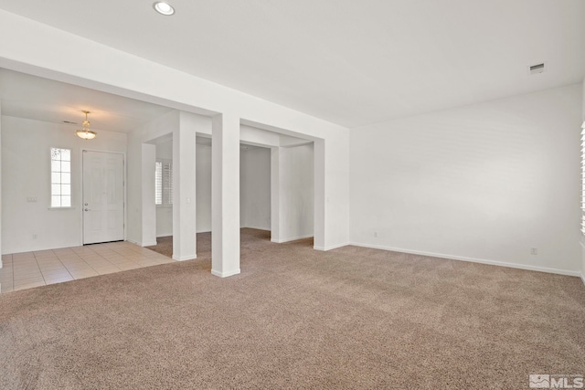 unfurnished living room featuring light colored carpet