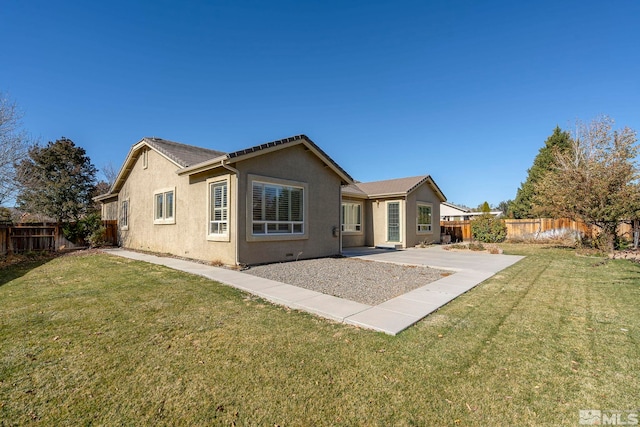 rear view of house with a patio and a lawn