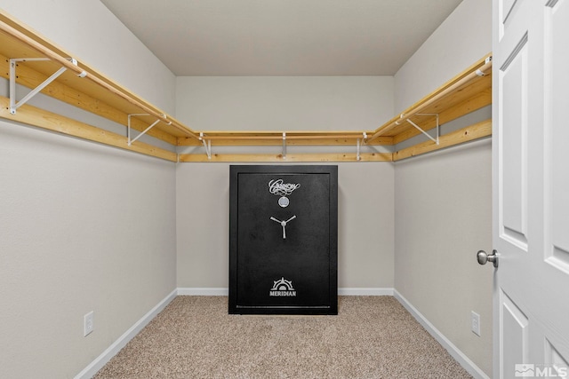 walk in closet featuring light colored carpet