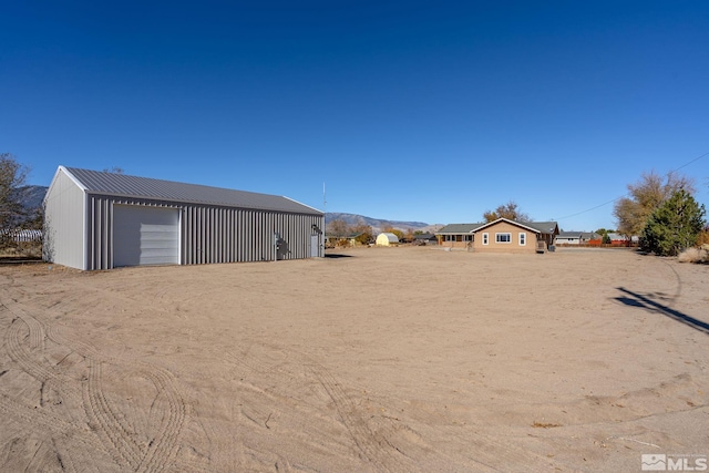 view of yard with a mountain view, a garage, and an outdoor structure