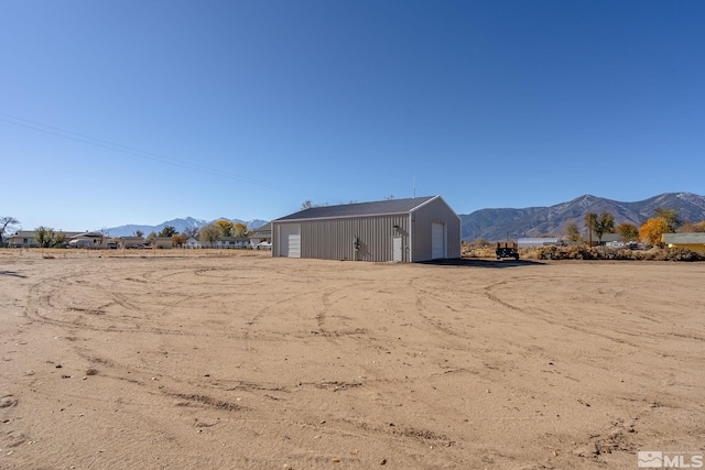 view of yard featuring an outbuilding, a garage, and a mountain view