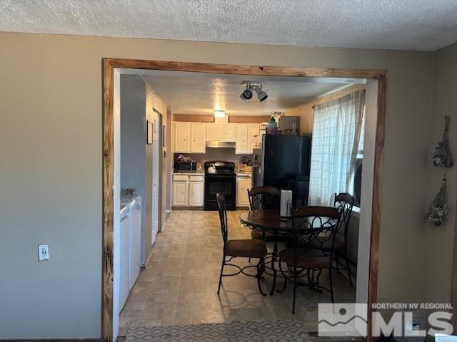 kitchen featuring black appliances, white cabinetry, and a textured ceiling