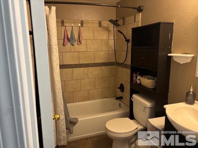 full bathroom featuring tile patterned floors, toilet, sink, and shower / tub combo