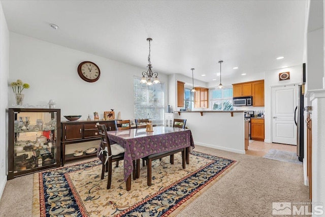 dining room with a chandelier and light carpet