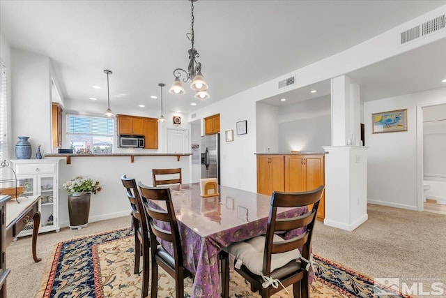 carpeted dining room with a chandelier