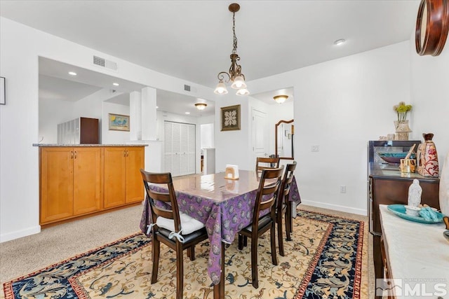 dining area featuring a chandelier and light colored carpet