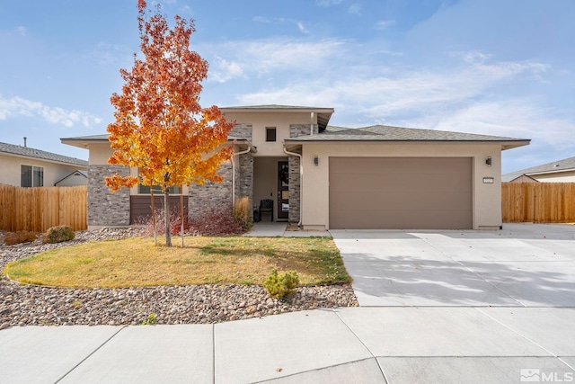 prairie-style house featuring a front lawn and a garage