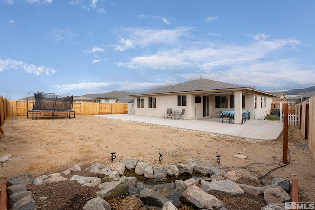 back of house featuring a patio area and a trampoline